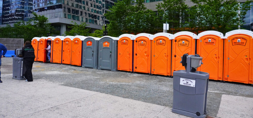 Portable restrooms set up for an outdoor event to help planners determine how many units they need