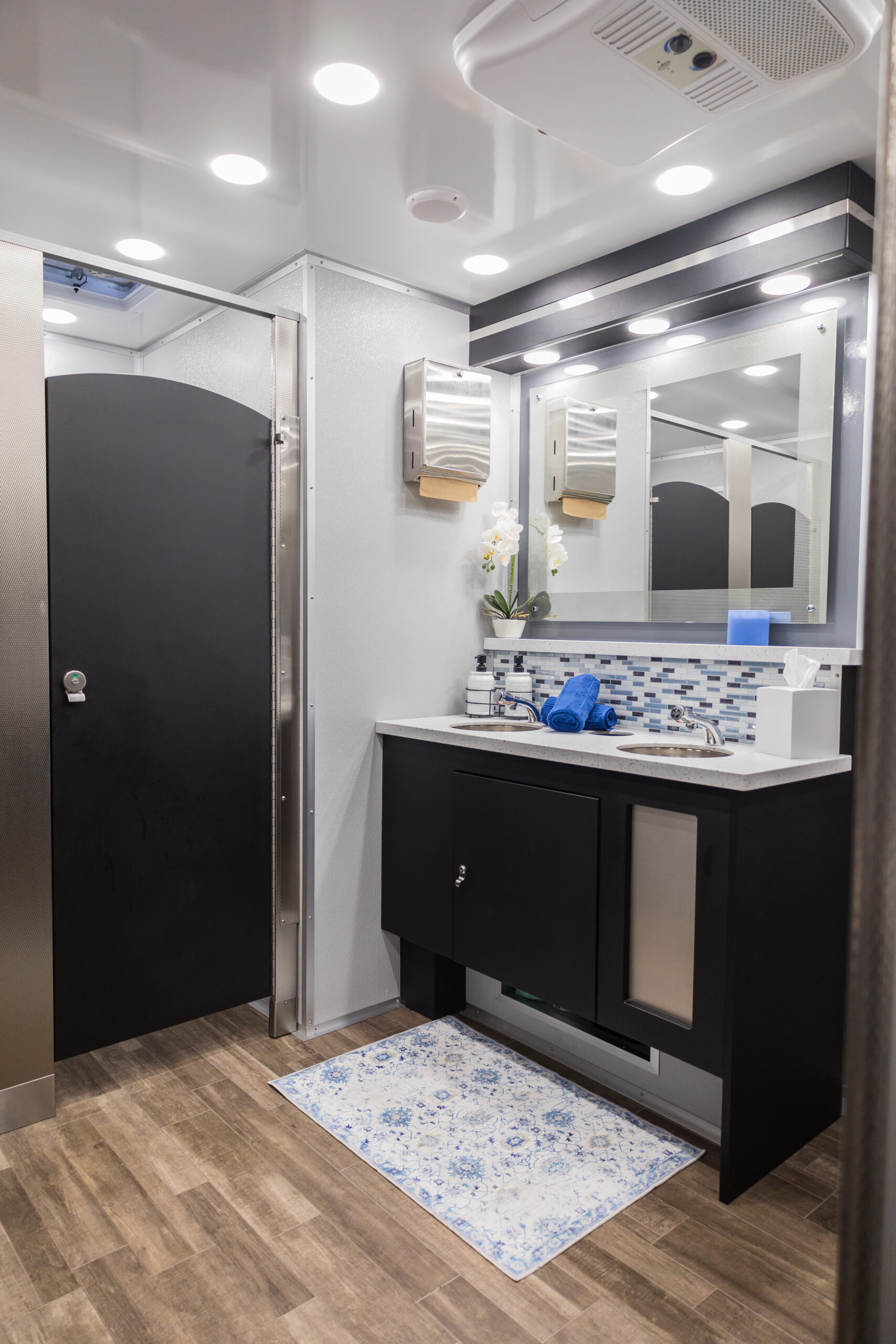 Interior of a luxury restroom trailer showing upscale amenities like private stalls and climate control