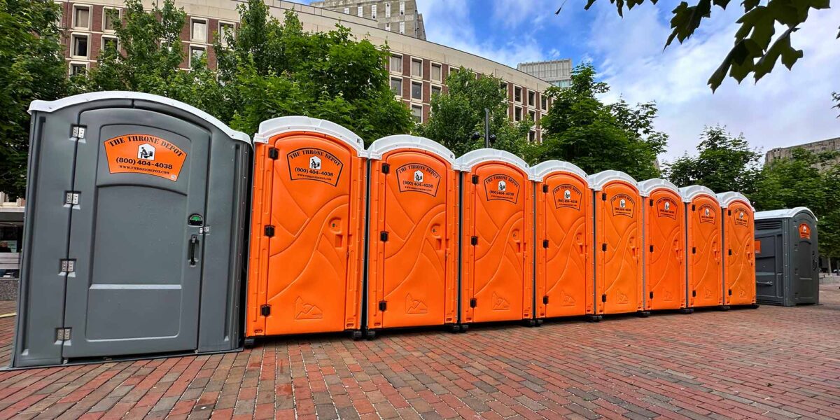 Portable toilets lined up at an outdoor event showing when porta potty rentals are needed