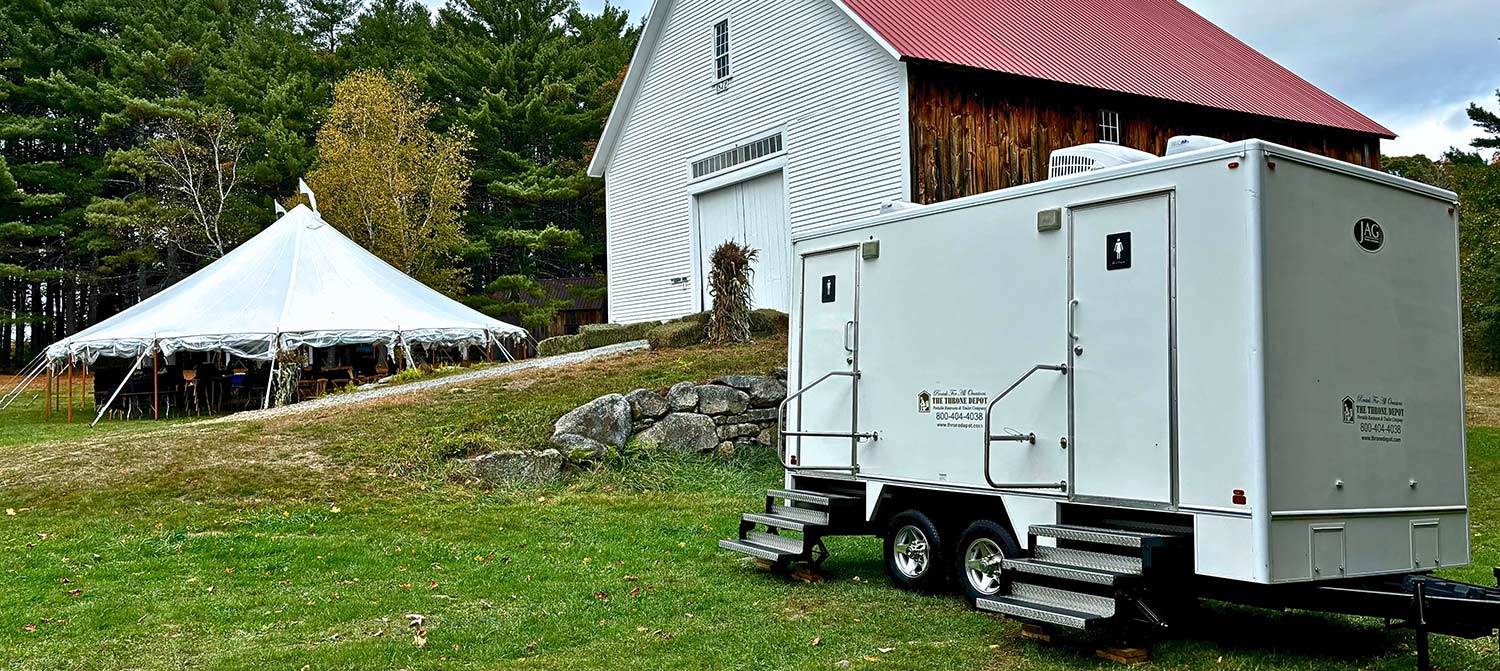 Restroom trailer set up at an event with attendants helping maintain cleanliness and guest comfort