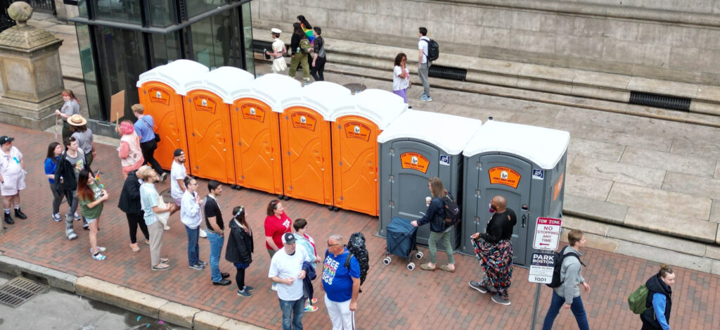 Row of portable toilets at an outdoor event showing typical porta potty use