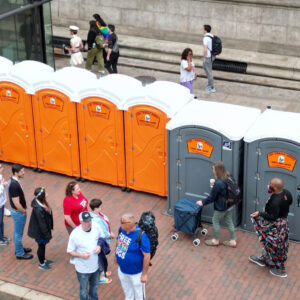 Row of portable toilets at an outdoor event showing typical porta potty use