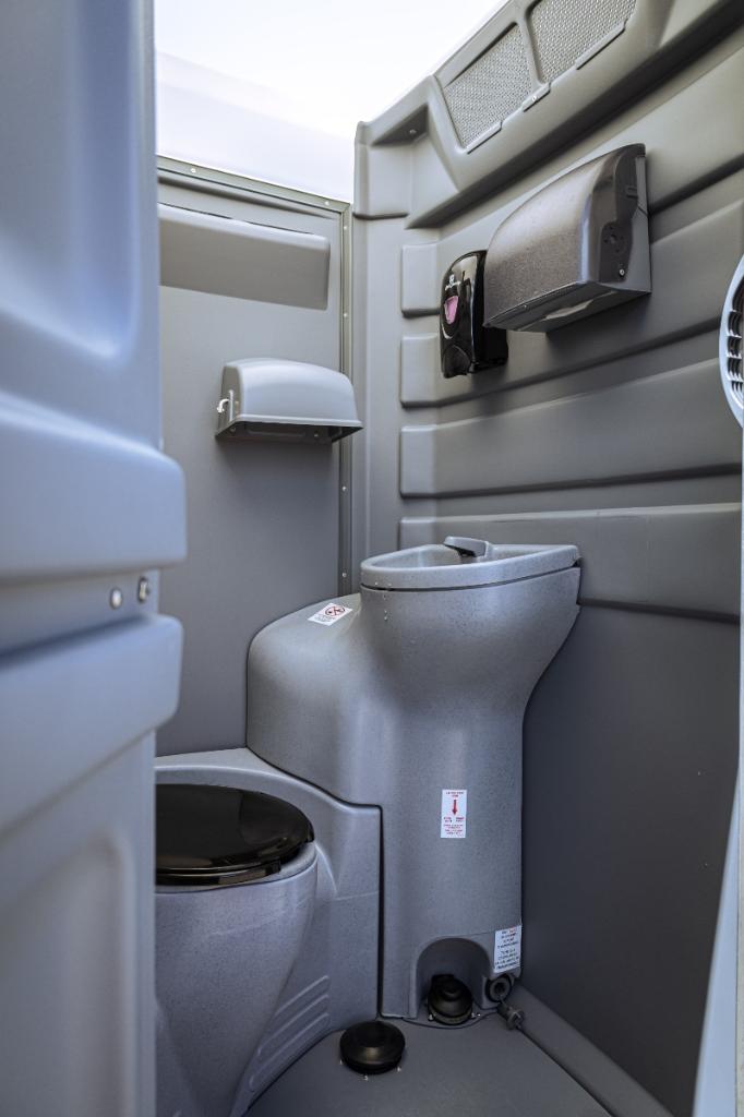 Interior of a Luxury VIP porta potty with upgraded finishes, foot-flush toilet, and handwashing sink
