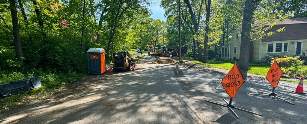 Portable toilet placed on a street during active road construction to support on-site crew productivity