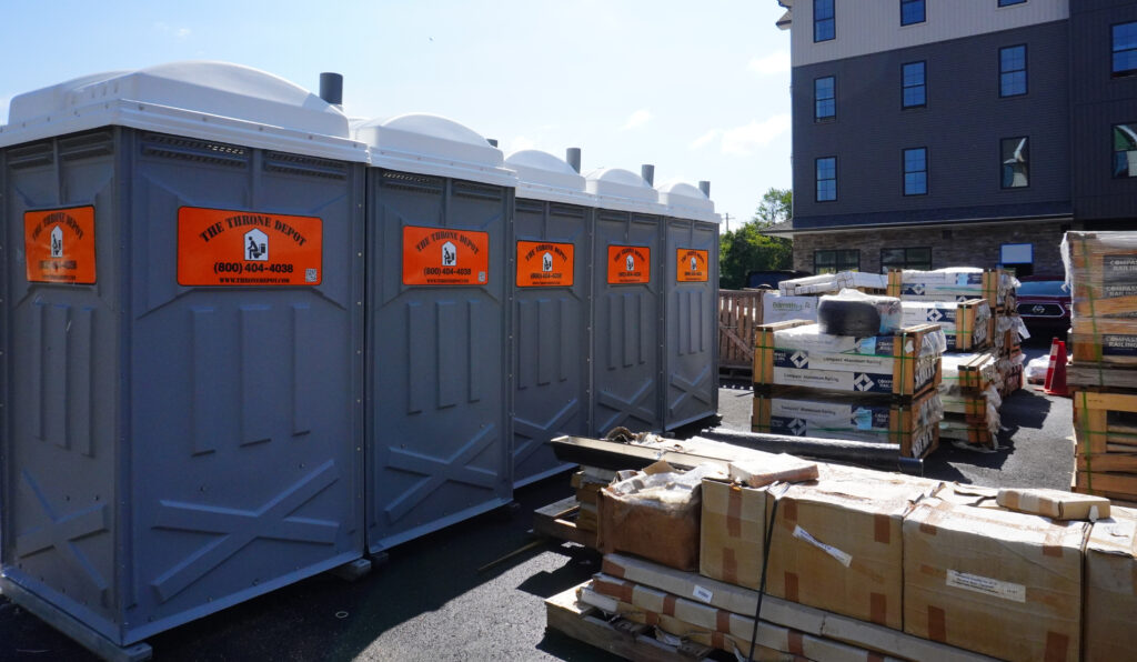 Portable restroom on an active construction site serviced under a guaranteed service program